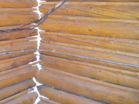 Foam sealant filling the gaps along the corner joints of a log wall