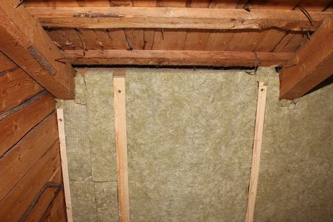 Mineral wool batts fitted between wooden studs beneath old timber rafters