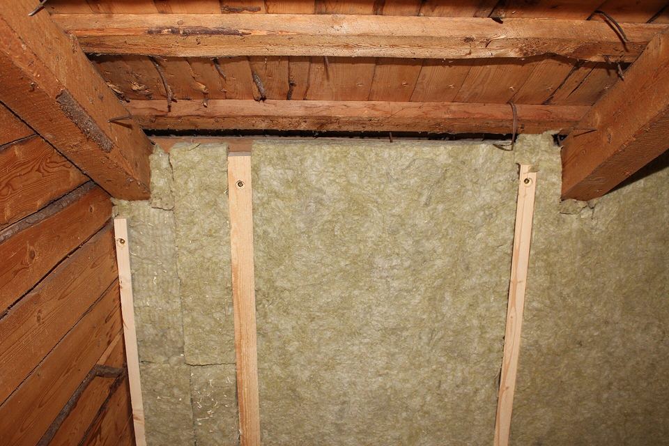Mineral wool batts fitted between wooden studs beneath old timber rafters